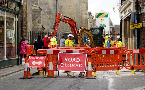 Roadworks in King's Lynn King’s Lynn, Norfolk, England - September 25, 2014: Near to the ancient Minster and Saturday Market Place, roadworks in the middle of St James’ Street in King's Lynn, Norfolk. Workmen gather around their hole in the road and pedestrians squeeze past on the narrow pavement. kings lynn stock pictures, royalty-free photos & images