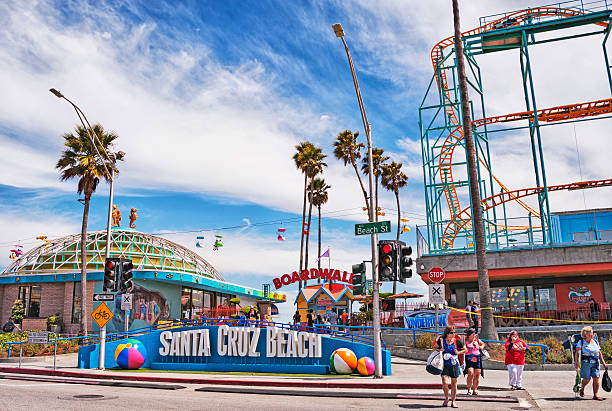 Santa Cruz, California, USA - June 11, 2013: These ladies seem to be leaving the Santa Cruz Boardwalk with all its amusement rides and shops right here along the main road for the famed Santa Cruz Boardwalk in Santa Cruz in Central California, this is one of the major beach amusement areas in California and very popular with many visitors the world over, and on  this June day the rides were running the crowds were enjoying and it was a perfect day to be at the beach. Camera is Nikon D3.                         