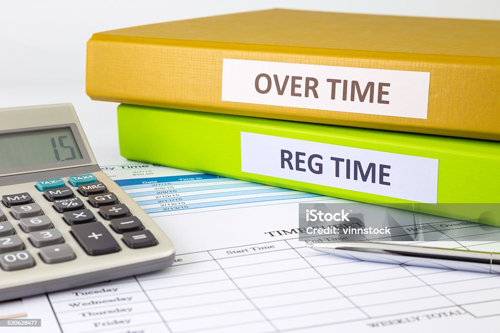 Daily time record with blank payroll time sheet Regular time and Over time words on labels, document binders place on blank payroll time sheets Working Late Stock Photo