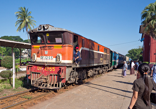 Yangon, Myanmar - November 13, 2014: Train arriving at Pan Hlaing Railway Station in Yangon, Myanmar. Myanmar has an extensive railway network, but trains and staitions are mostly old and run down.