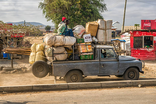 Arusha, Tanzania - October 21, 2014 : African men transporting goods in an old car