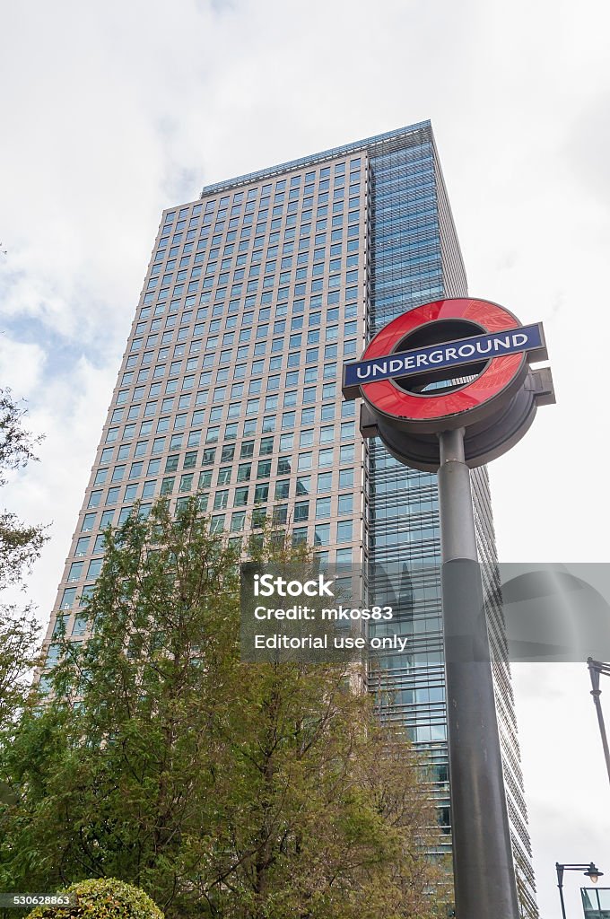 The London Underground sign in Canary Wharf London, United Kingdom - November 9, 2014: The London Underground sign in Canary Wharf with modern skyscraper in the background. Architecture Stock Photo