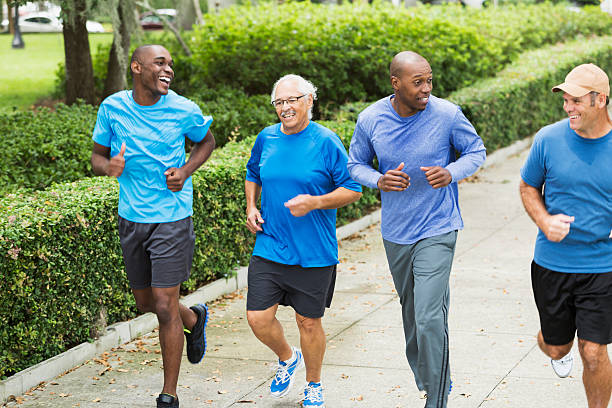 istock Four multiracial men jogging in park 530629057