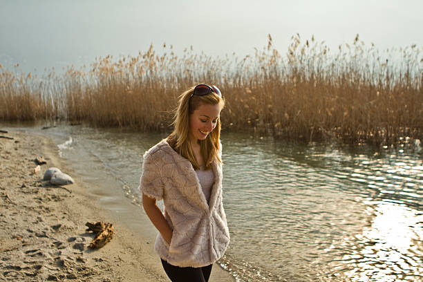 Happy young woman smiling walking on the beach during a sunny lovely day.