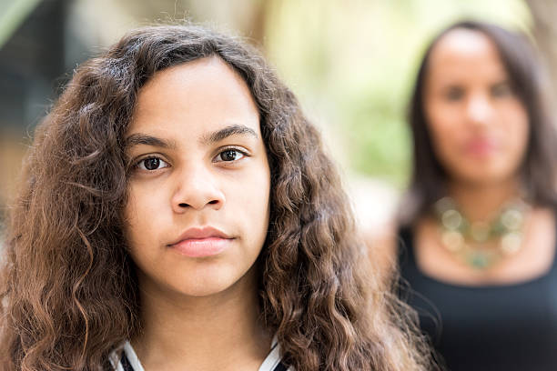 Mother and daughter Serious hispanic teenage girl posing with her mother in the background puerto rican ethnicity stock pictures, royalty-free photos & images