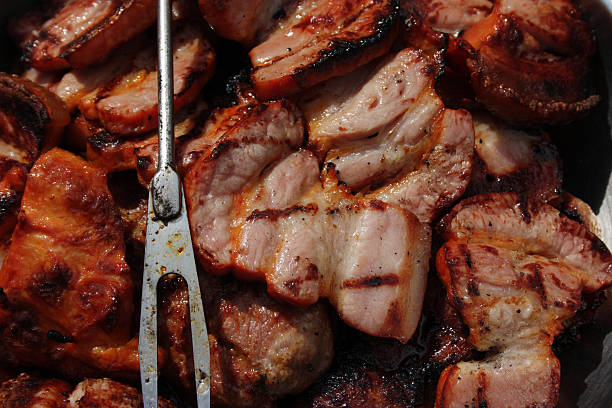 Barbecuing meat on charcoal fire closeup image.