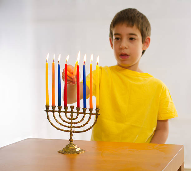 istock Israeli boy lighting a Hannukah Menorah 530637591