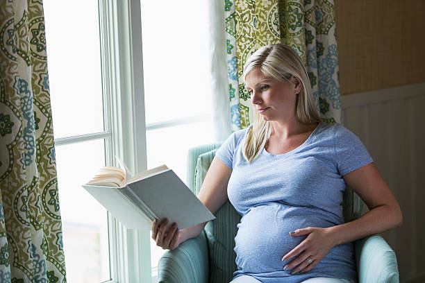 беременная женщина, чтения - human pregnancy rubbing looking down abdomen стоковые фото и изображения