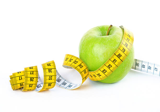 istock Measuring tape wrapped around a green apple 530639049