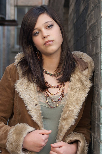 istock Thirteen Year Old Leaning Against Brick Wall in Winter Coat 530639825