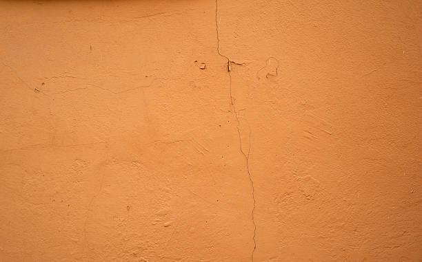 istock Texture of old wall covered with yellow stucco 530642109