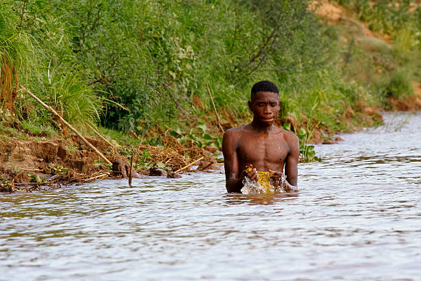 istock African poor man taking a bath in river, Madagascar 530649551