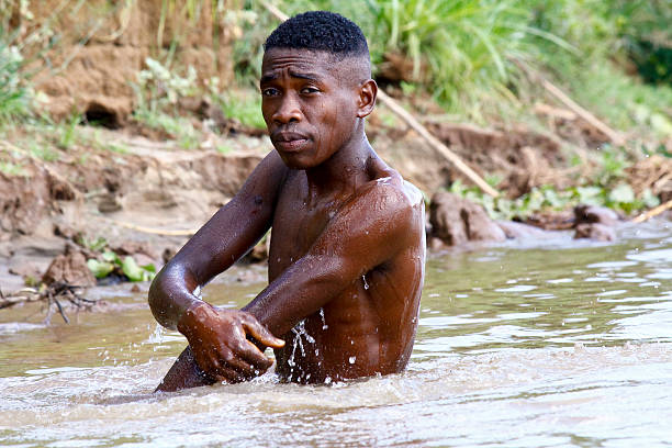 istock African poor man taking a bath in river, Madagascar 530649575