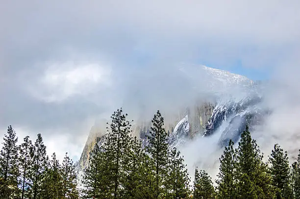 Half Dome at Yosemite National Park During winter with fog streaking across the front.