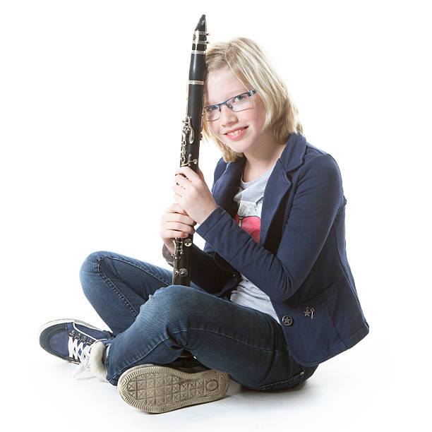 istock young blond girl sits and holds clarinet in studio 530650281
