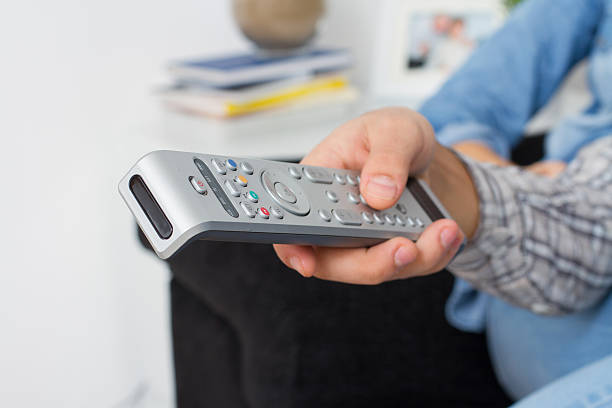 istock Closeup of hand with remote control at home 530650985