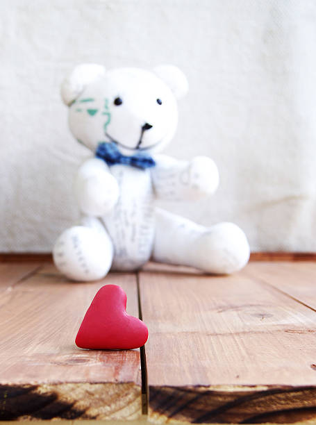 istock Heart and teddy bear on a wooden surface 530653027