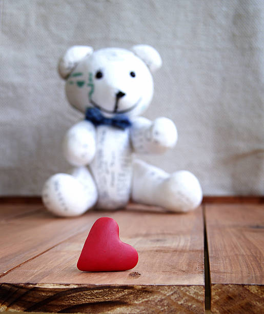 istock Heart and teddy bear on a wooden surface 530653029