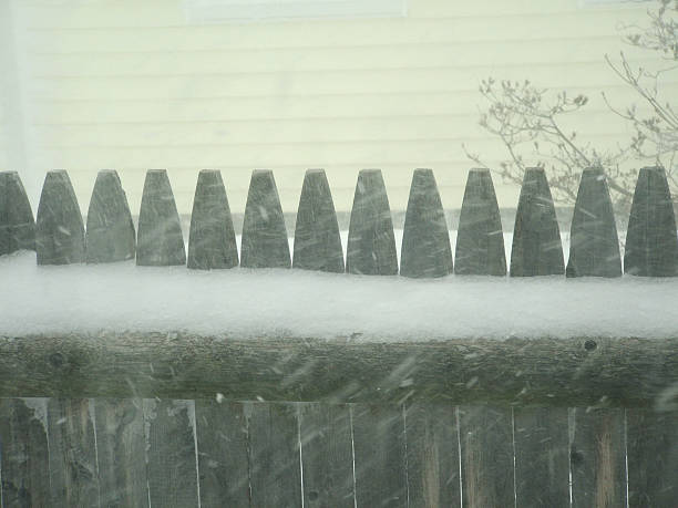 Snow covered fence in a snow storm stock photo