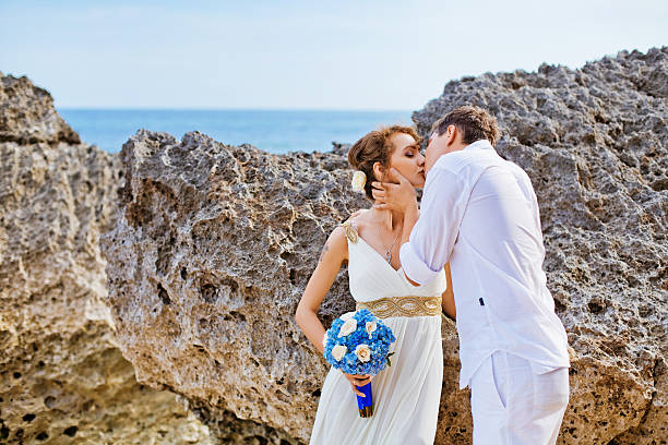 istock Bride and groom kissing on the beach 530660397
