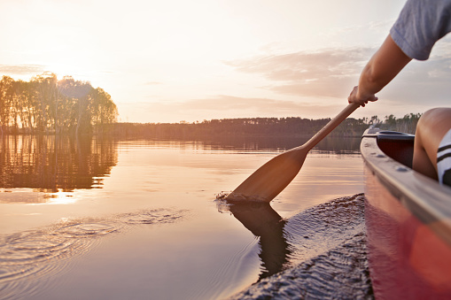 Woman canoeing at sunset on Jackfish Lake, Manitoba.