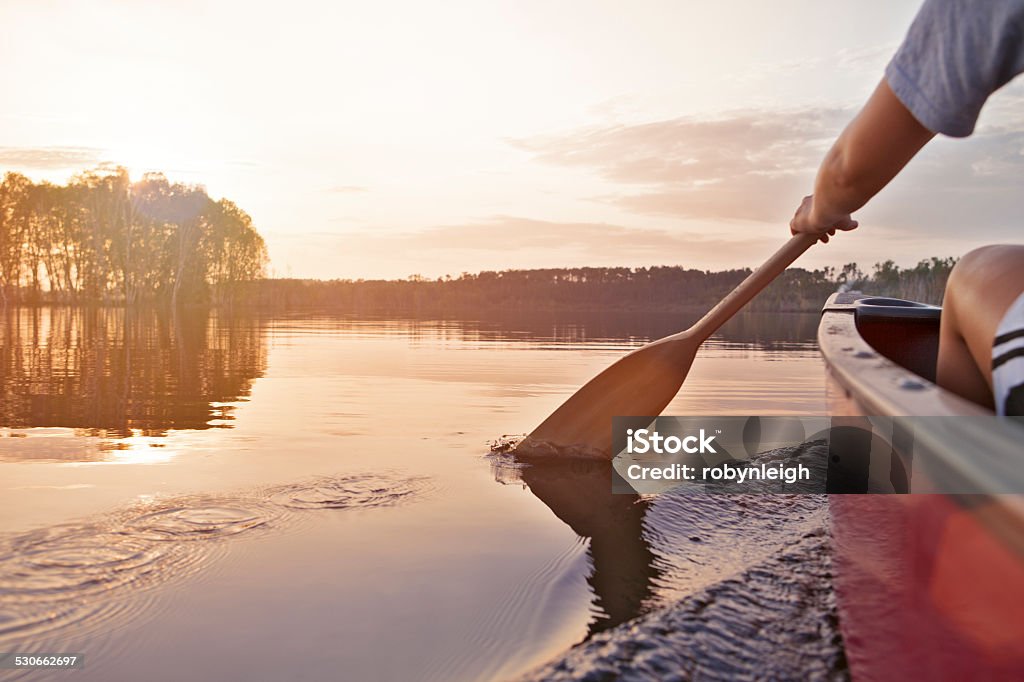 Woman canoeing at sunset Woman canoeing at sunset on Jackfish Lake, Manitoba. Canoeing Stock Photo