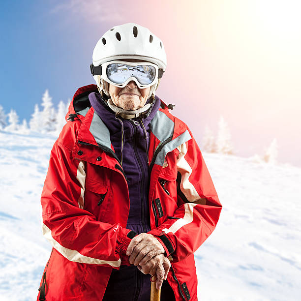 Senior woman in ski jacket and goggles outdoors. With clipping path.
