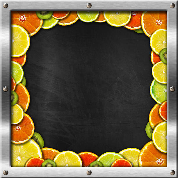 Blackboard with metal frame and screws with oranges, lemons and kiwi.