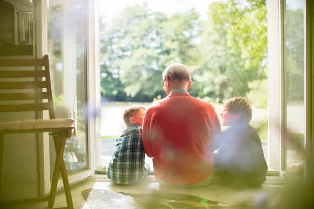 Grandfather and grandsons sitting in doorway  grandparent stock pictures, royalty-free photos & images