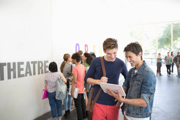 istock Two university friends looking at tablet in corridor 530682719