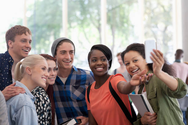 istock University students taking selfie in corridor during break 530682939