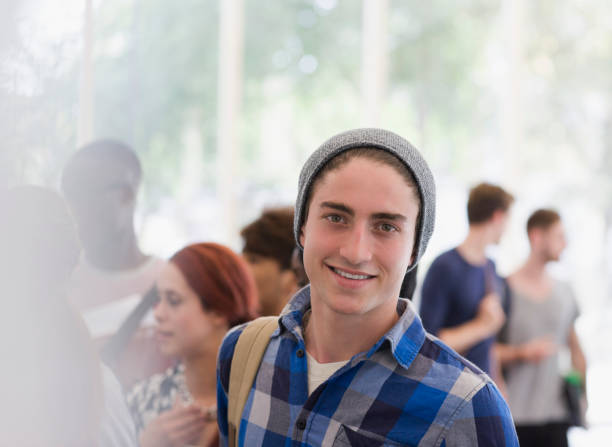 retrato de estudiante universitario sonriente durante el descanso, gente hablando de fondo - student london england teenage girls teenager fotografías e imágenes de stock