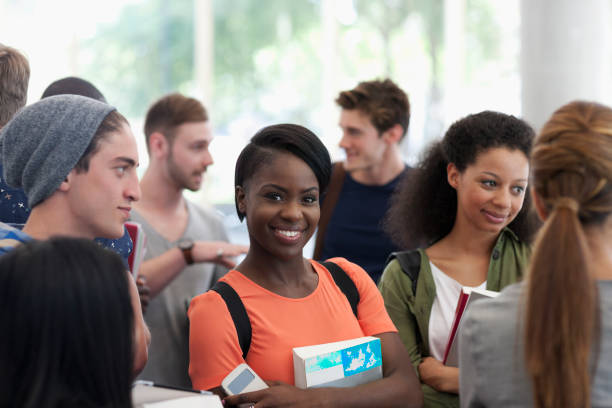 istock Smiling university student carrying book and looking at camera 530683019