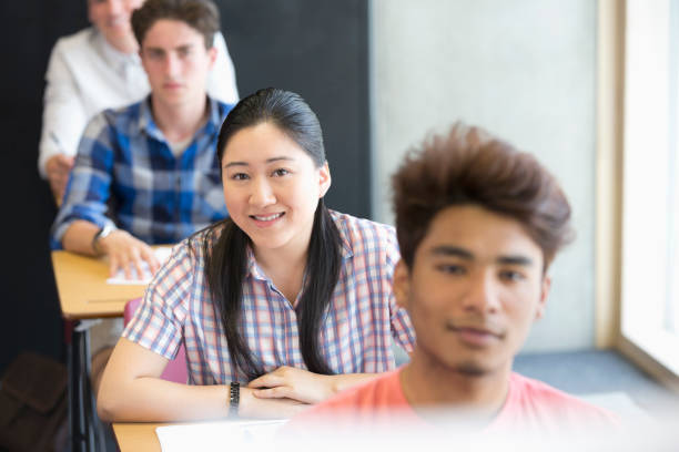 istock Portrait of smiling university students sitting in classroom 530683027