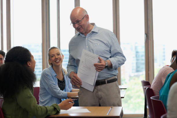 istock Teacher talking with students during lecture in sunlit classroom 530683119