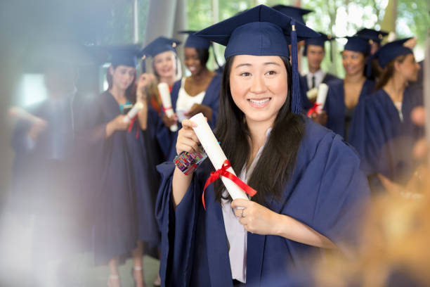 retrato de una estudiante sonriente vestida con vestido de graduación sosteniendo el diploma - japanese ethnicity college student asian ethnicity asian and indian ethnicities fotografías e imágenes de stock