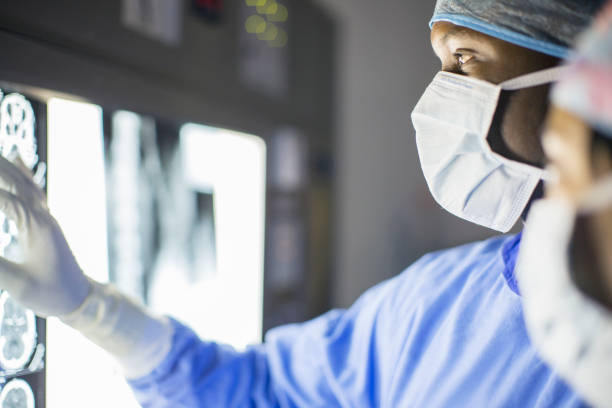 homem adulto médio examinando pacientes ressonância magnética - oncologia - fotografias e filmes do acervo