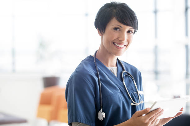 Portrait of female doctor with stethoscope around neck, holding digital tablet  18797 stock pictures, royalty-free photos & images