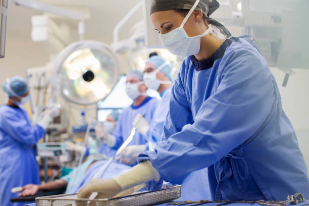 infirmière portant des gommages préparant des instruments médicaux en bloc opératoire - bloc photos et images de collection