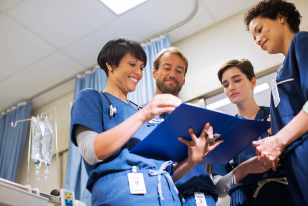 istock Doctors wearing scrubs, looking at documents in hospital ward 530685297