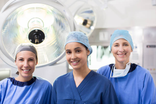 ritratto di tre chirurghi in sala operatoria - female nurse nurse scrubs female doctor foto e immagini stock