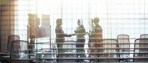 Business people standing in conference room shaking hands  board room stock pictures, royalty-free photos & images