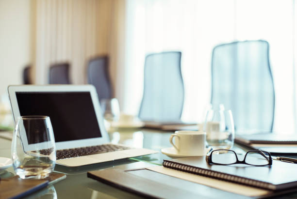 istock Laptop, eyeglasses and diary on conference table in empty conference room 530685847