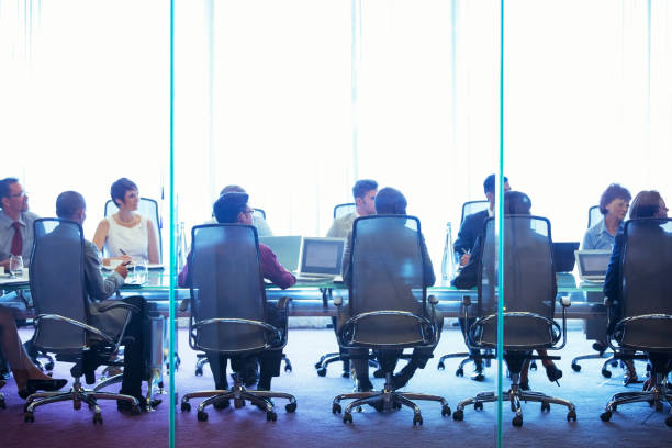 uomini d'affari che si riuniscono in sala conferenze, seduti con i computer portatili e discutono - office water business meeting foto e immagini stock