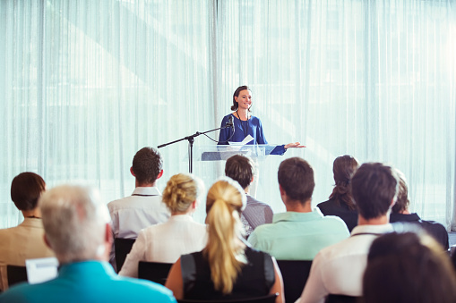 Businessman in a conference hall with many people in the audience