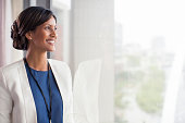 istock Portrait of smiling mid adult woman looking through window 530686091