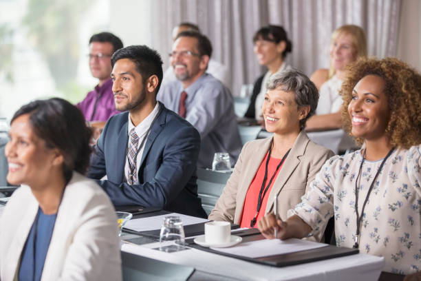 grupo de personas sentadas y escuchando el discurso durante el seminario - 30s adult authority caucasian fotografías e imágenes de stock