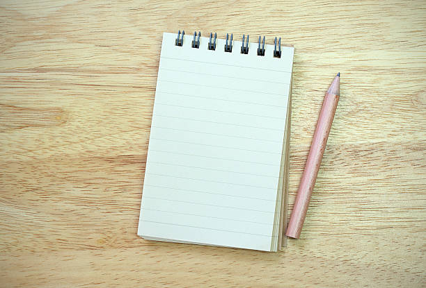 istock note book with pencil on wood table 530693795