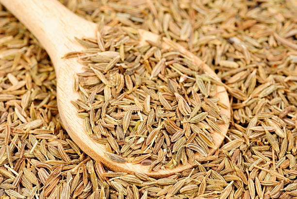 istock Cumin seeds macro and wooden spoon as background 530694933