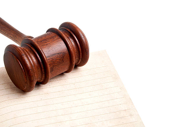 istock Wooden gavel and open notebook isolated on white background 530696519